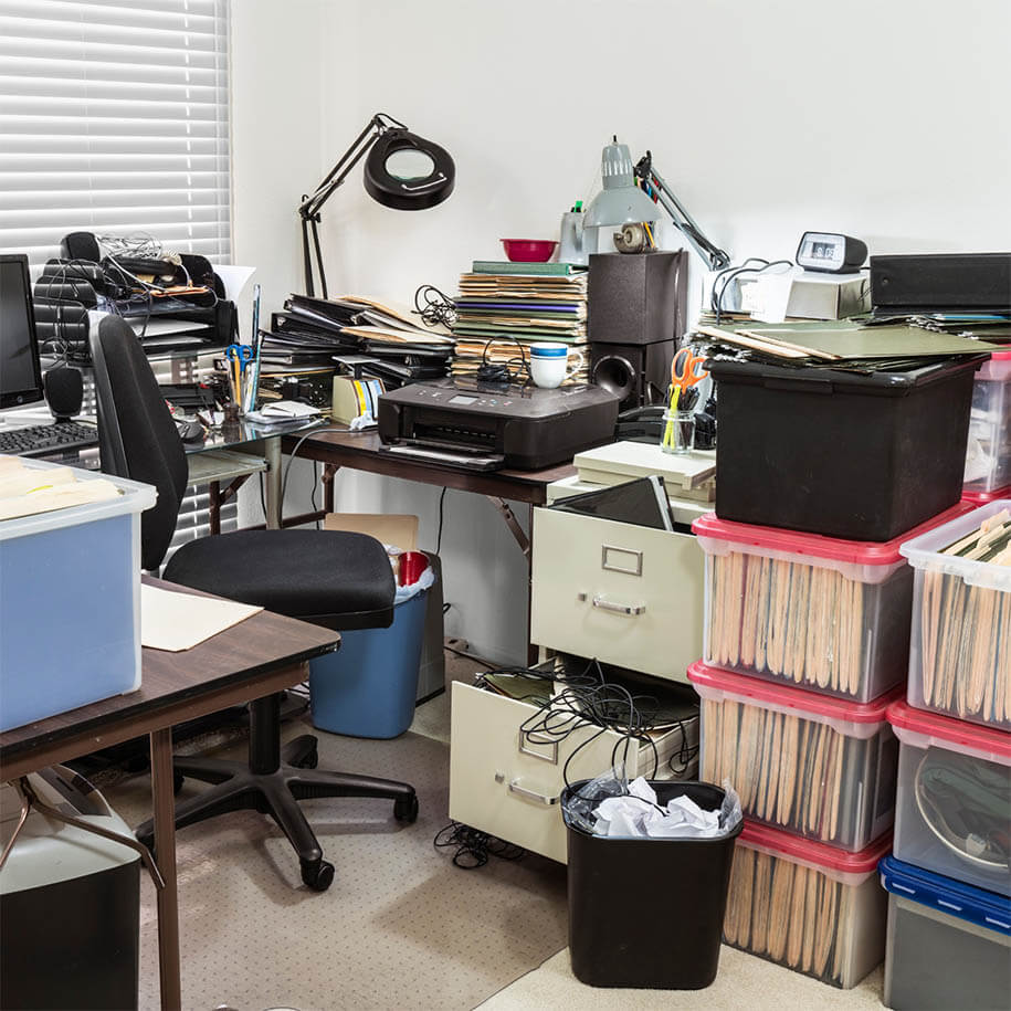Unordentliches Büro mit Kisten voller Akten und einem vollen Tisch. - Entrümpelung - Rümpelvergleich